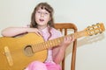 Young little girl playing acoustic guitar Royalty Free Stock Photo