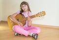 Young little girl playing acoustic guitar Royalty Free Stock Photo