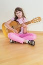 Young little girl playing acoustic guitar Royalty Free Stock Photo