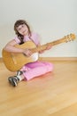 Young little girl playing acoustic guitar Royalty Free Stock Photo