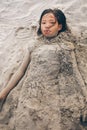 Young little girl playing on the beach covered with the sand Royalty Free Stock Photo