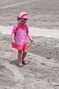 Young little girl playing with the sand and building sandcastle at the beach near the sea. Royalty Free Stock Photo