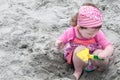 Young little girl playing with the sand and building sandcastle at the beach near the sea. Royalty Free Stock Photo