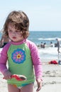 Young little girl playing with the sand and building sandcastle at the beach near the sea. Royalty Free Stock Photo