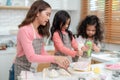 Young little girl standing at counter baking bakery in the modern kitchen at home. Happy smiling parents enjoy weekend. Child and Royalty Free Stock Photo