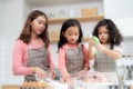 Young little girl standing at counter baking bakery in the modern kitchen at home. Happy smiling parents enjoy weekend. Child and Royalty Free Stock Photo