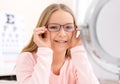 Young little girl trying glasses at the optician