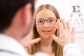 Young little girl trying glasses at the optician