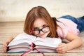 Young little girl wearing glasses and reading a book Royalty Free Stock Photo