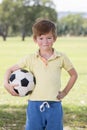 Young little kid 7 or 8 years old enjoying happy playing football soccer at grass city park field posing smiling proud standing ho Royalty Free Stock Photo