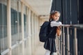 Young little school girl in uniform standing in hallway with package of dinner in hands Royalty Free Stock Photo