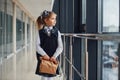Young little school girl in uniform standing in hallway with package of dinner in hands Royalty Free Stock Photo