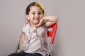 Young little two years old girl seat on a red chair in front of Royalty Free Stock Photo