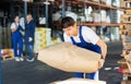 Young guy loading bags on cart in warehouse Royalty Free Stock Photo
