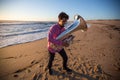 Young lone musician with a tuba playing on the sea beach