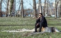 Young lonely depressed and anxious man sitting alone in the park on the wooden stump disappointed in his life crying and thinking Royalty Free Stock Photo