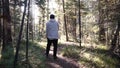 Young lonely man walking deep into forest among dense vegetation and bushes. Footage. View of man from back walking on Royalty Free Stock Photo