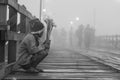 Young lonely poor boy selling flowers at Mon wooden bridge in cold morning Royalty Free Stock Photo