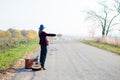 Young lonely woman and baby hitchhiking on rural