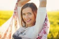 Young long hair woman dancing in yellow flowers field, holding scarf behind, closeup detail, afternoon sun backlight background Royalty Free Stock Photo