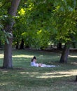 Young, long-haired, dark-haired woman on a picnic in the park in summer dress. Royalty Free Stock Photo