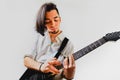 Young long haired guitarist excited playing his black electric guitar, isolated on white background Royalty Free Stock Photo