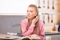 Young long-haired woman sitting with book at table Royalty Free Stock Photo