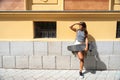 Young longboard skater woman with skateboard standing on the urban street in the city holding her board waiting her friend to go Royalty Free Stock Photo