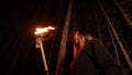 Young lost woman with long hair standing in winter forest at night with a handmade torch Royalty Free Stock Photo