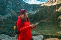 Young lost woman traveler with map and backpack relaxing outdoor with rocky on Morskie Oko lake. Woman traveler explorer Royalty Free Stock Photo