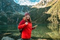 Young lost woman traveler with map and backpack relaxing outdoor with rocky on Morskie Oko lake. Woman traveler explorer Royalty Free Stock Photo