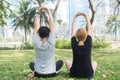 Young love couple making a meditation to calm their mind after exercising in park encircle with a warm light sunshine in afternoon