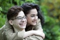 Young love couple in the park. Girl embracing the guy and look Royalty Free Stock Photo