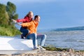 Young love Couple sit on boat on coast of river Royalty Free Stock Photo