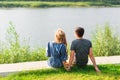 Young love couple sitting on the river bank in summer Royalty Free Stock Photo