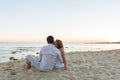 Young love couple sitting together on beach Royalty Free Stock Photo