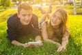 Young lovely couple or college students lying down on the grass together, listening to music. Royalty Free Stock Photo