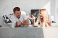 Young lovely couple have a breakfast at home while lying down on bed Royalty Free Stock Photo