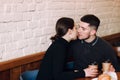 Young lovely couple kissing while sitting in cafe Royalty Free Stock Photo