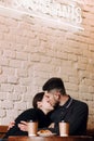 Young lovely couple kissing while sitting in cafe Royalty Free Stock Photo