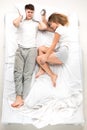 The young lovely couple lying in a bed with alarm clock Royalty Free Stock Photo