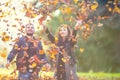 Young lovely happy couple - lovers flying with leaves in autumn park Royalty Free Stock Photo