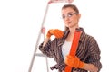 Young lovely woman with dark hair in uniforl makes renovations with tools in her hands isolated on white background