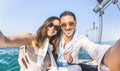 Young lover couple taking selfie on sailing boat tour around the world - Love concept at jubilee party cruise on luxury sailboat