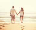 Young Lovers Walking Down the Beach at Sunset Royalty Free Stock Photo