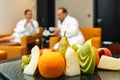 Young loving Caucasian honeymoon couple of man and woman in white bathrobes drinking tea and talking after spa with different fres Royalty Free Stock Photo