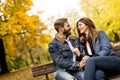 Young loving couple on the bench in the autumn park Royalty Free Stock Photo