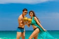 Young loving couple drink coconut on tropical beach. Summer vacation concept. Royalty Free Stock Photo