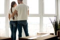 Young couple embracing in new apartment with packed belongings