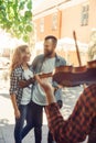 Young loving couple enjoying street musician with a violin Royalty Free Stock Photo